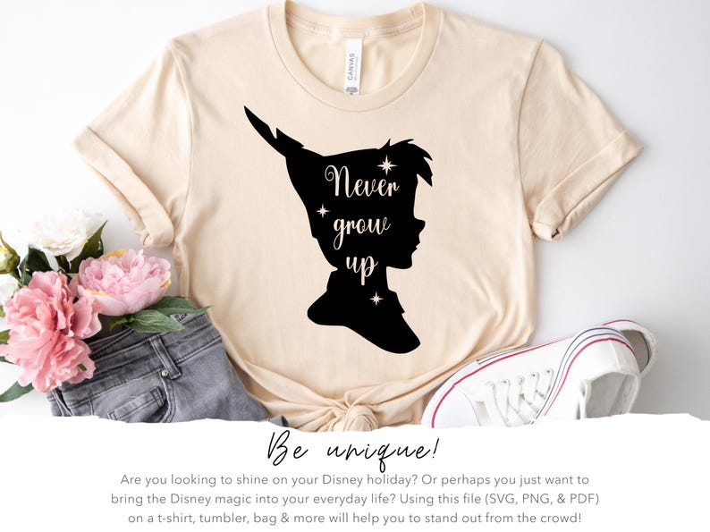 Może przedstawiać: Beżowa koszulka z czarną sylwetką Piotrusia Pana i napisem "Never grow up".