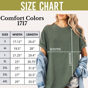 May include: Olive green Comfort Colors 1717 t-shirt with a size chart. The chart shows measurements for width and length in inches for sizes S through 4XL. The shirt is being modeled.