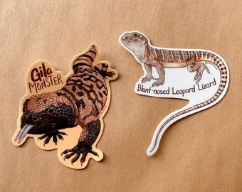 May include: Two stickers featuring illustrations of lizards. The first sticker shows a Gila Monster with the text "Gila Monster". The second sticker shows a Blunt-nosed Leopard Lizard with the text "Blunt-nosed Leopard Lizard".