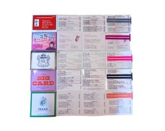 May include: A set of five folded score cards for the National Mah Jongg League, each featuring distinct cover designs including text like In My Mahjong Era, The Big Card, and Texas, alongside interior grids with printed rules and scoring data.
