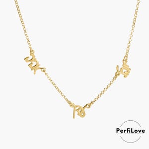 May include: Gold necklace with three names, "Jack", "Ray", and "Faith", written in cursive script.