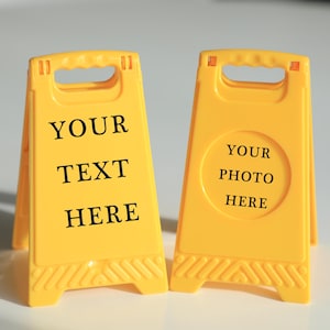Könnte beinhalten: Zwei gelbe Warnschilder mit schwarzem Text. Das Schild links sagt "Your Text Here". Das Schild rechts sagt "Your Photo Here".