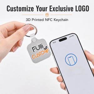 May include: A square 3D printed NFC keychain with a silver finish and a metal ring. The keychain features the black and orange text "Fulli custom" with a gift icon. A smartphone is held nearby, displaying a blue icon for NFC scanning.