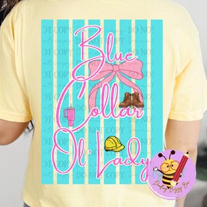 May include: Yellow t-shirt with a graphic on the back that says "Blue Collar Ol' Lady" in pink script. The design includes a pink bow, work boots, a hard hat, and a tumbler. A cartoon bee with a pencil is in the lower right corner.