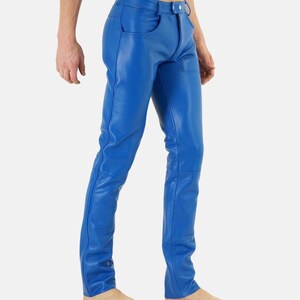 May include: Bright blue leather pants with a classic five-pocket design. The pants have a button and zipper closure and are form-fitting. The leather appears smooth and has visible stitching details. The pants are a vibrant, solid color.