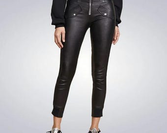 May include: Black leather pants with a zipper down the front and a high waist. The pants have pockets on the front and a cuffed hem.
