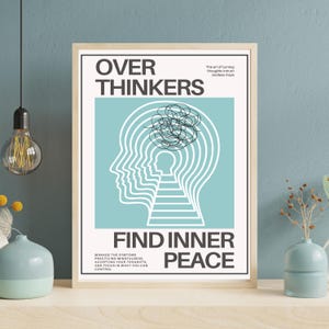 May include: A framed poster with the words "OVER THINKERS" at the top and "FIND INNER PEACE" at the bottom. The poster features a light blue background with a white outline of a head and a maze-like design. The text "The art of turning thoughts into an endless maze" is also included.