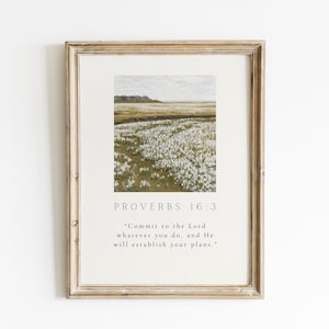 May include: Framed print featuring a landscape image of a field of white flowers and a light brown frame. The text "PROVERBS 16:3" is at the top, with a quote below: "Commit to the Lord whatever you do, and He will establish your plans."