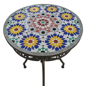 May include: Round mosaic tile table with a decorative starburst pattern in yellow, blue, red, and green. The table has a dark metal frame and legs. The table is approximately 30 inches in diameter.