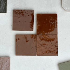May include: Four square brown ceramic tiles with a glossy finish. The tiles are arranged in a two by two grid.