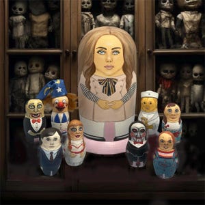 May include: A collection of hand-painted wooden nesting dolls, featuring a large doll with a woman's face and smaller dolls with various character designs. The dolls are displayed in front of a cabinet filled with antique dolls.