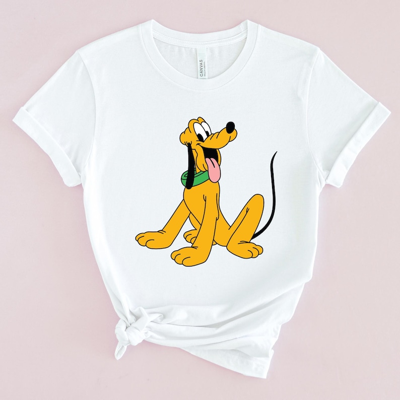 May include: White t-shirt with a cartoon image of Pluto, a yellow dog with a green collar, sitting and looking to the right.