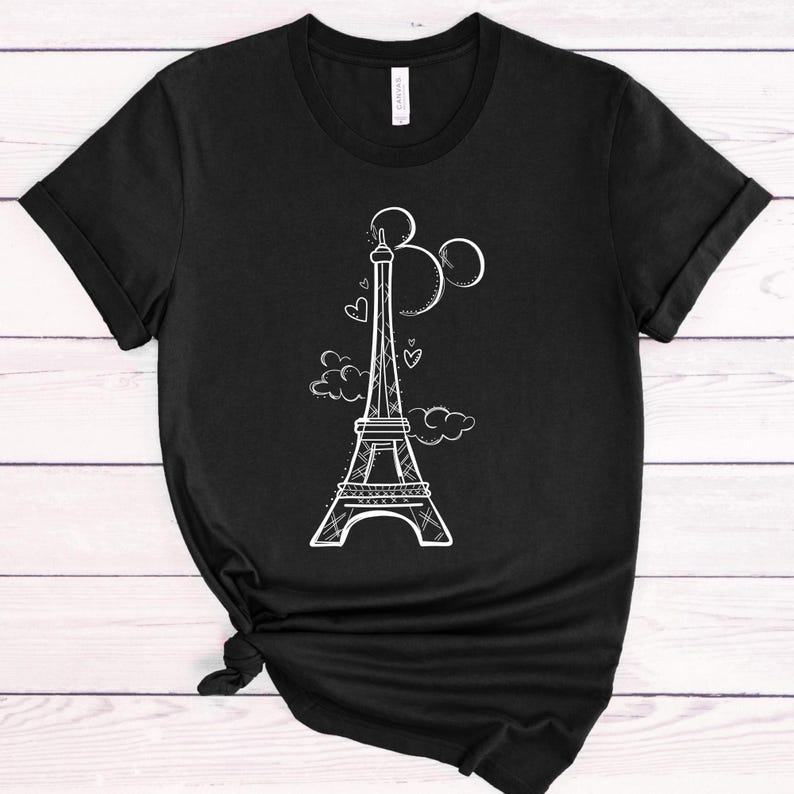 May include: Black t-shirt featuring a white outline of the Eiffel Tower, Mickey Mouse ears, and hearts. The design is centred on the shirt.