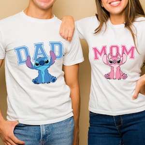 May include: Two white short-sleeved t-shirts. The left shirt features the blue text DAD with a blue Stitch character graphic. The right shirt features the pink text MOM with a pink Angel character graphic. Both shirts have a crew neckline.