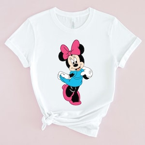May include: White t-shirt with a cartoon image of Minnie Mouse wearing a blue dress and a pink bow.