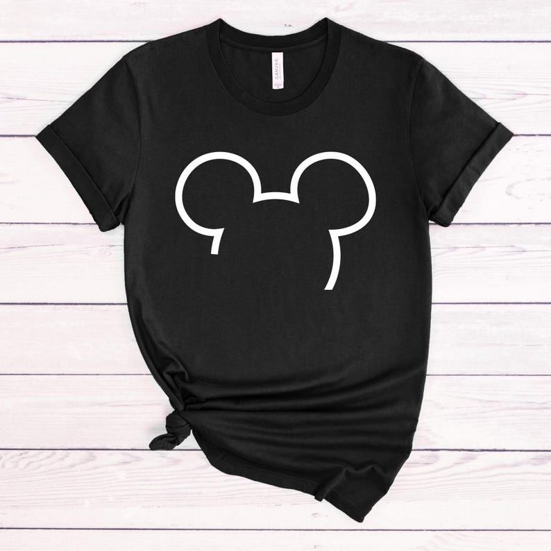 Puede incluir: Camiseta negra con un contorno blanco de las orejas de Mickey Mouse.