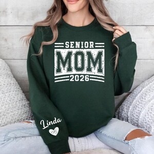 Senior Mom Crewneck, Class of 2026 Parent Shirt, Graduation Support Mom Tee, Personalized Name Sleeve Shirt, Varsity College Style Mom Sweatshirt, Proud Senior Mom Clothing, High School Senior Outfit, Graduation Season Apparel, Senior Year Mom Shirt, Custom Sleeve Print Shirt, School Spirit Wear Mom, Game Day Mom Clothing, Senior Parent Gift Shirt, Grad 2026 Tee