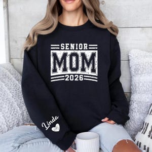 High School Senior Mom Shirt, Graduation Mom 2026 Tee, Senior Year Parent Sweatshirt, Personalized Sleeve Design Shirt, Senior Mom Varsity Print Crewneck, Class of 2026 Support Shirt, Proud Senior Mom Outfit, Graduation Event Apparel, School Spirit Mom Top, Senior 2026 Clothing, Custom Name Heart Sleeve Shirt, Graduation Celebration Tee, Senior Family Shirt