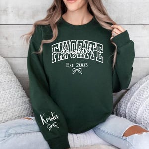 mom of daughters sweatshirt favorite daughter design, personalized est year daughter shirt with sleeve name, black pink white print mom sweatshirt, meaningful gift for mom from daughter, trendy varsity mom apparel
