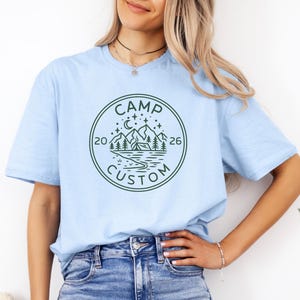 camp custom t shirt with year 2026 outdoorsy adventure tee minimalist camping logo mountain scene forest trees night sky moon stars travel vacation shirt