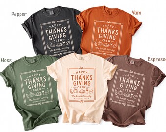 May include: Five short-sleeve crew neck t-shirts in pepper, yam, moss, cream, and espresso colors. Each shirt features a white graphic print with the text "HAPPY THANKSGIVING CREW," "The Smith Family," and "NASHVILLE 2024" alongside icons of a pumpkin, turkey, wine glass, and football.