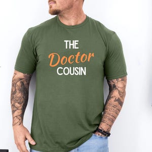 A man wearing a green t-shirt with the text "THE DOCTOR COUSIN" printed on it.
