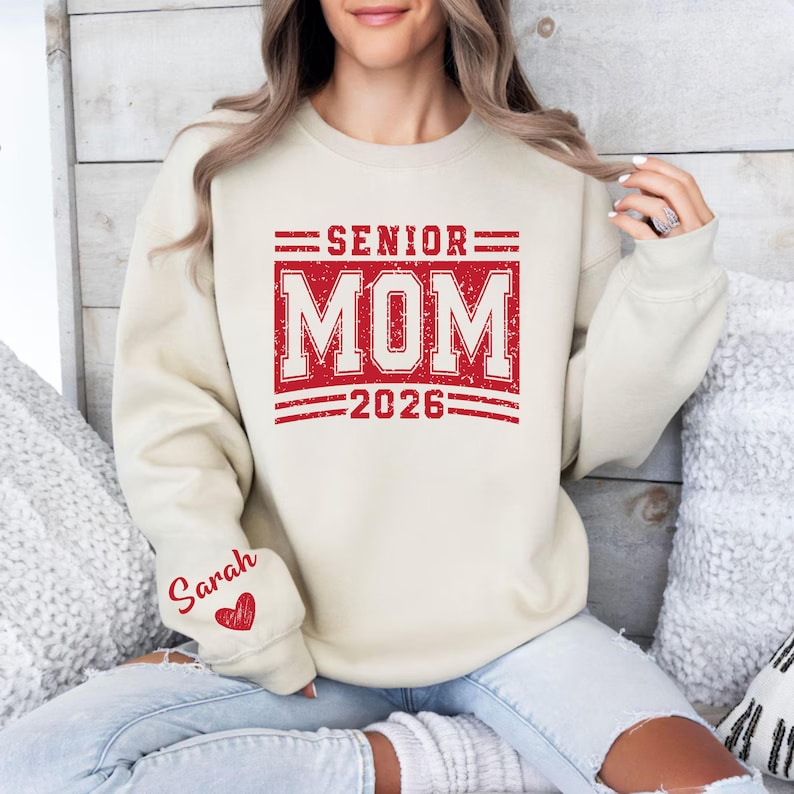 Senior 2026 Mom Shirt, Graduation Mom Apparel, Custom Name Sleeve Sweatshirt, Senior Year School Spirit Shirt, Class of 2026 Varsity Mom Tee, Senior Parent Outfit, Proud Mom Graduation Top, Personalized Heart Sleeve Shirt, High School Grad Mom Shirt, Supportive Parent Clothing, Senior Night Apparel, Graduation Season Outfit, Senior Mom Graphic Shirt