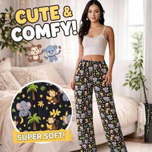 May include: Black pajama pants with a repeating pattern of elephants, monkeys, palm trees, and bananas. The text "CUTE & COMFY!" and "SUPER SOFT!" are displayed. A woman is wearing the pants with a white crop top.