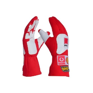 Könnte beinhalten: Ein Paar rote Rennhandschuhe mit weißen Akzenten und Logos. Die Handschuhe haben eine weiße Handfläche und Finger, und der Handrücken ist rot mit weißen Nähten. Die Logos beinhalten "Vodafone", "OMP" und "JB", und die Handschuhe sind für den Rennsport konzipiert.