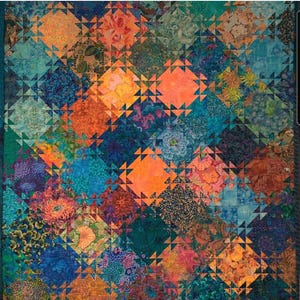 May include: A quilt with a geometric pattern of orange, blue, and brown squares and triangles. The fabric has a floral pattern.
