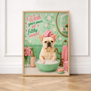 Op de afbeelding: Een ingelijste print met een Franse Bulldog in een badkamer. De hond zit in een groene kom met bubbels en draagt een roze handdoek. De print bevat de tekst "Wash your paws, ya filthy animal."