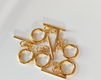 May include: Gold-toned metal toggle clasps with a round ring and a straight bar. The clasps are perfect for jewelry making and crafting.