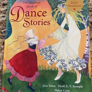 May include: The Barefoot Book of Dance Stories, a children's book cover featuring a girl in a red dress dancing with a fairy in a white dress. The book includes a story CD by Juliet Stevenson.