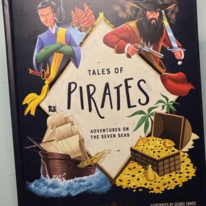 May include: A hardcover book titled "Tales of Pirates" with illustrations of pirates, a treasure chest, and a ship. The cover features a dark blue background with gold accents and the names of the authors and illustrator.