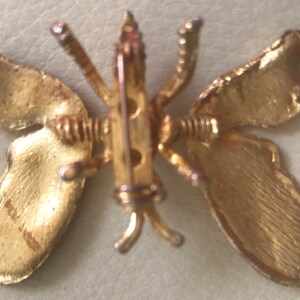 Puede incluir: Broche de mariposa dorada con un dise&ntilde;o detallado. Las alas son texturizadas y la broche tiene un cierre de pin.