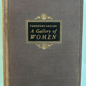 May include: A brown book with gold lettering on the cover. The title is "A Gallery of Women" by Theodore Dreiser.
