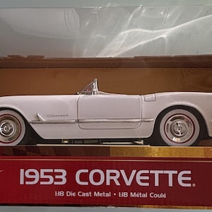 May include: A white 1953 Corvette die-cast model car in its original box. The model is a 1:18 scale replica with white wall tires. The box features the text "1953 Corvette" and "50th Anniversary Collection".