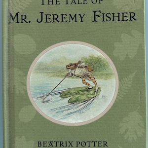 May include: The Tale of Mr. Jeremy Fisher book cover featuring a green background with a circular illustration of a frog wearing a white shirt and brown pants, holding a stick and riding on lily pads on a blue lake. The book cover also includes the title "The Tale of Mr. Jeremy Fisher" and the author's name "Beatrix Potter".