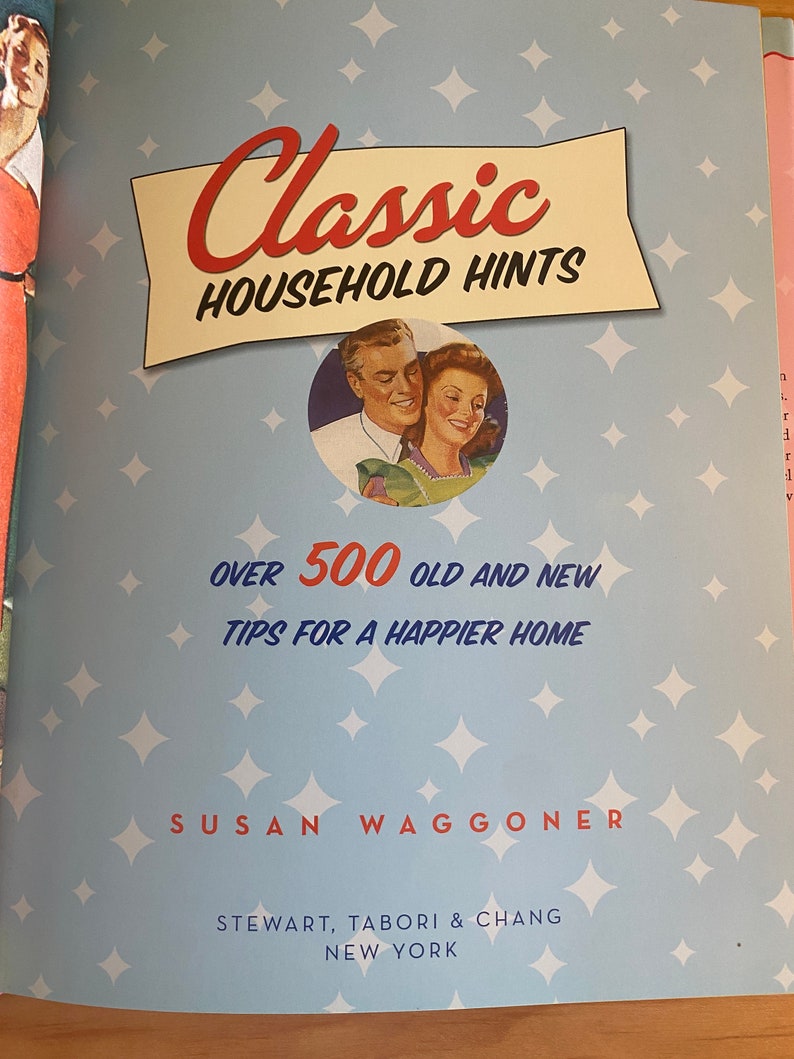 Pode incluir: Uma capa de livro com fundo azul e estrelas brancas. O t&iacute;tulo &eacute; "Classic Household Hints" em letras vermelhas. O subt&iacute;tulo &eacute; "Over 500 Old and New Tips for a Happier Home". A autora &eacute; Susan Waggoner. A editora &eacute; Stewart, Tabori & Chang, New York.