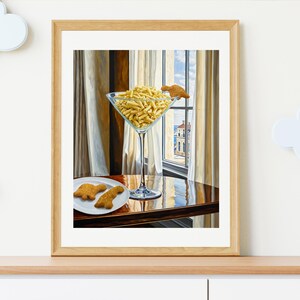 May include: A painting of a martini glass filled with yellow pasta, with a small cookie on the rim. Two more cookies are on a plate on a wooden table, with a window in the background.