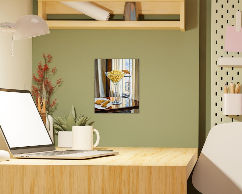 May include: A painting of a glass martini glass filled with yellow french fries, sitting on a wooden table with a plate of cookies in the background. The glass is on a white tablecloth and the table is in front of a window.