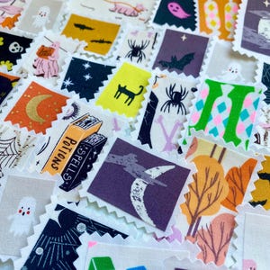 May include: A collection of Halloween-themed fabric squares with various designs. The squares feature images of bats, spiders, ghosts, cats, moons, and pumpkins in orange, black, purple, and white. Some squares have text that reads "Potions" and "Spells".
