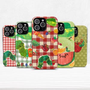 以下が含まれることがあります： カラフルなイラストが描かれた、5つの携帯電話ケース。幼虫と様々な果物が描かれています。ケースは赤と緑のギンガムチェック、水玉模様、その他のパターンが特徴です。幼虫は緑色で、果物にはリンゴ、イチゴ、スイカなどがあります。