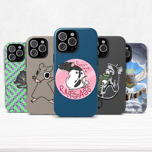 May include: Five phone cases with quirky rat-themed designs. One case has the phrase "I don't give a rats-ass". The cases are in shades of green, grey, and blue, showcasing various cartoon rat illustrations.