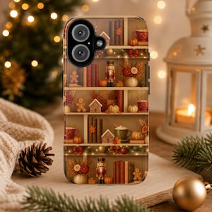 May include: A smartphone case featuring a printed design of wooden bookshelves filled with autumn and winter decor, including nutcrackers, gingerbread figures, small pumpkins, mugs, books, and miniature houses, all arranged on multiple shelves.