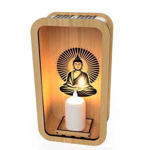 May include: A wooden Buddha candle holder with a warm, inviting glow. The design features a silhouette of Buddha with a radiant halo, and a white candle. The frame is made of light-colored wood.