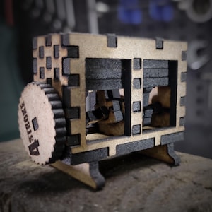 May include: A wooden model of a 4-stroke engine with a black and brown color scheme. The model has a small crank on the side that can be turned.