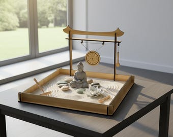 May include: A miniature zen garden with a wooden frame, sand, and a small Buddha statue. The garden includes smooth stones, a lotus flower, and a wooden gong. A small rake and other accessories are included. The garden sits on a dark table.