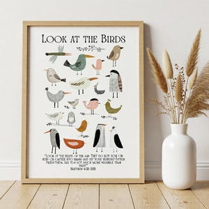 Könnte beinhalten: Ein gerahmter Kunstdruck mit einer Sammlung von illustrierten Vögeln in verschiedenen Farben und Formen. Der Text "LOOK AT THE BIRDS" steht oben, darunter ein Zitat aus Matthäus 6:26. Das Kunstwerk befindet sich in einem Holzrahmen.