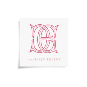 May include: A square white card with a pink monogram design featuring the intertwined letters "D" and "E". The name "DANIELLE EBBERT" is printed in a smaller font below the monogram. The design has a classic, elegant style.
